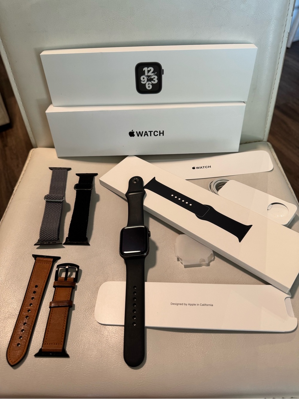 Apple Watch SE 44mm with Black Sport Band & Assorted Gray, Black, & Brown Straps